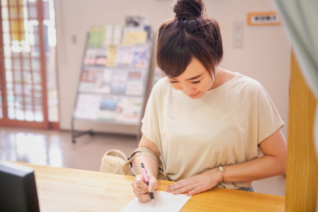 役所で申込みをする女性